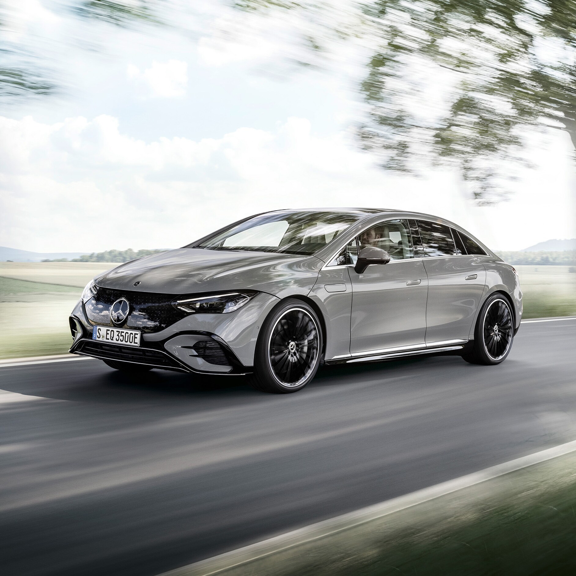 Mercedes-Benz EQS limuzyna w widoku z przodu. Mercedes-Benz EQS Limuzyna na drodze wśród drzew.