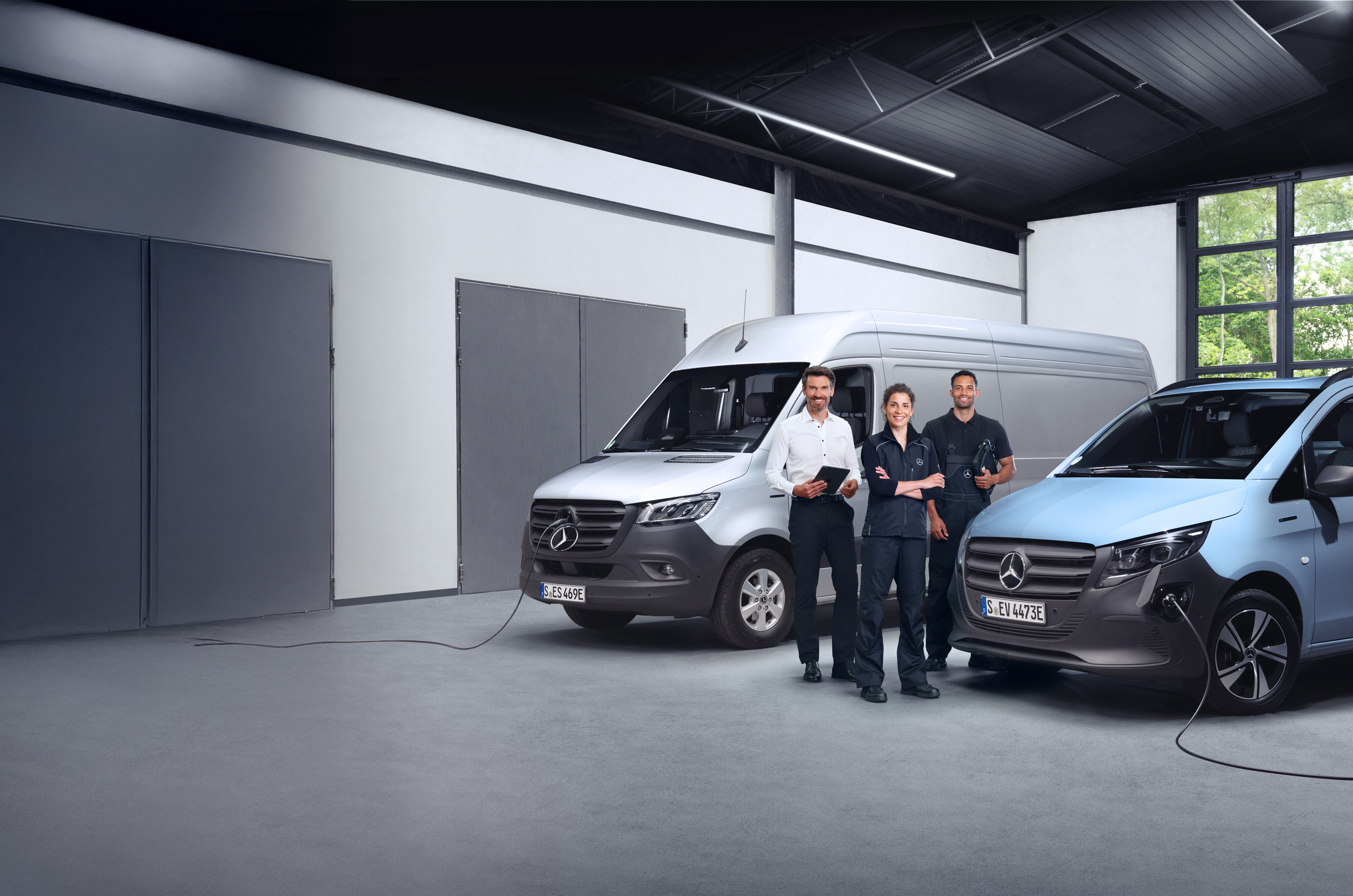 Jakość | Samochody dostawcze Mercedes-Benz Trzech pracowników stojących przed samochodami dostawczymi Mercedes-Benz.