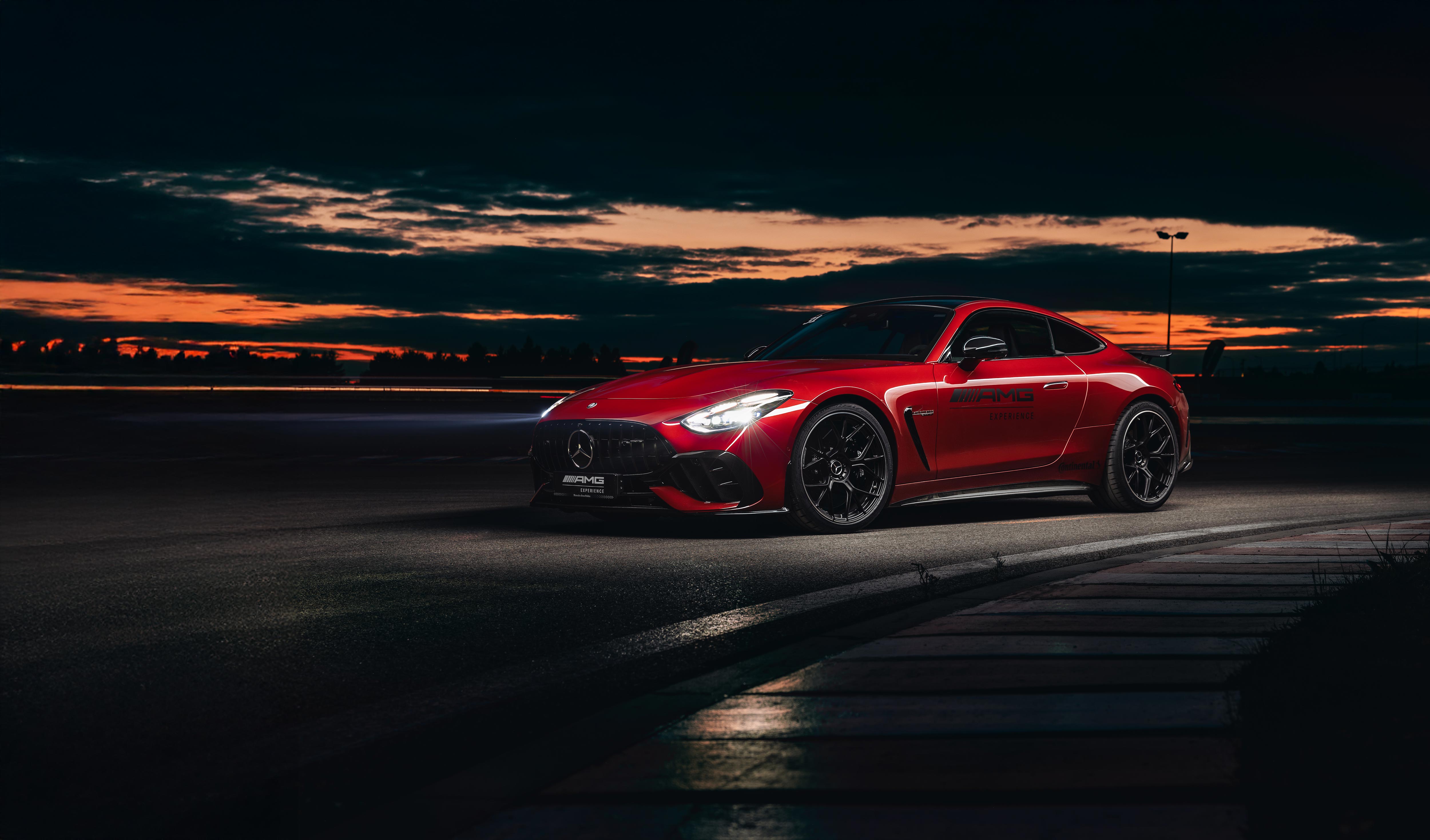 Czerwony Mercedes-AMG GT Coupé z logo AMG Experience na drzwiach.
